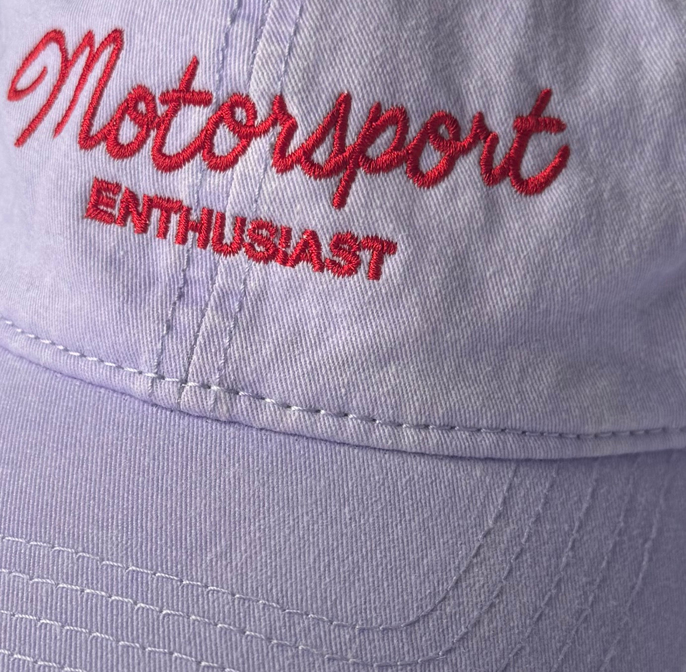 Close-up of red Motorsport Enthusiast embroidery on lavender cap