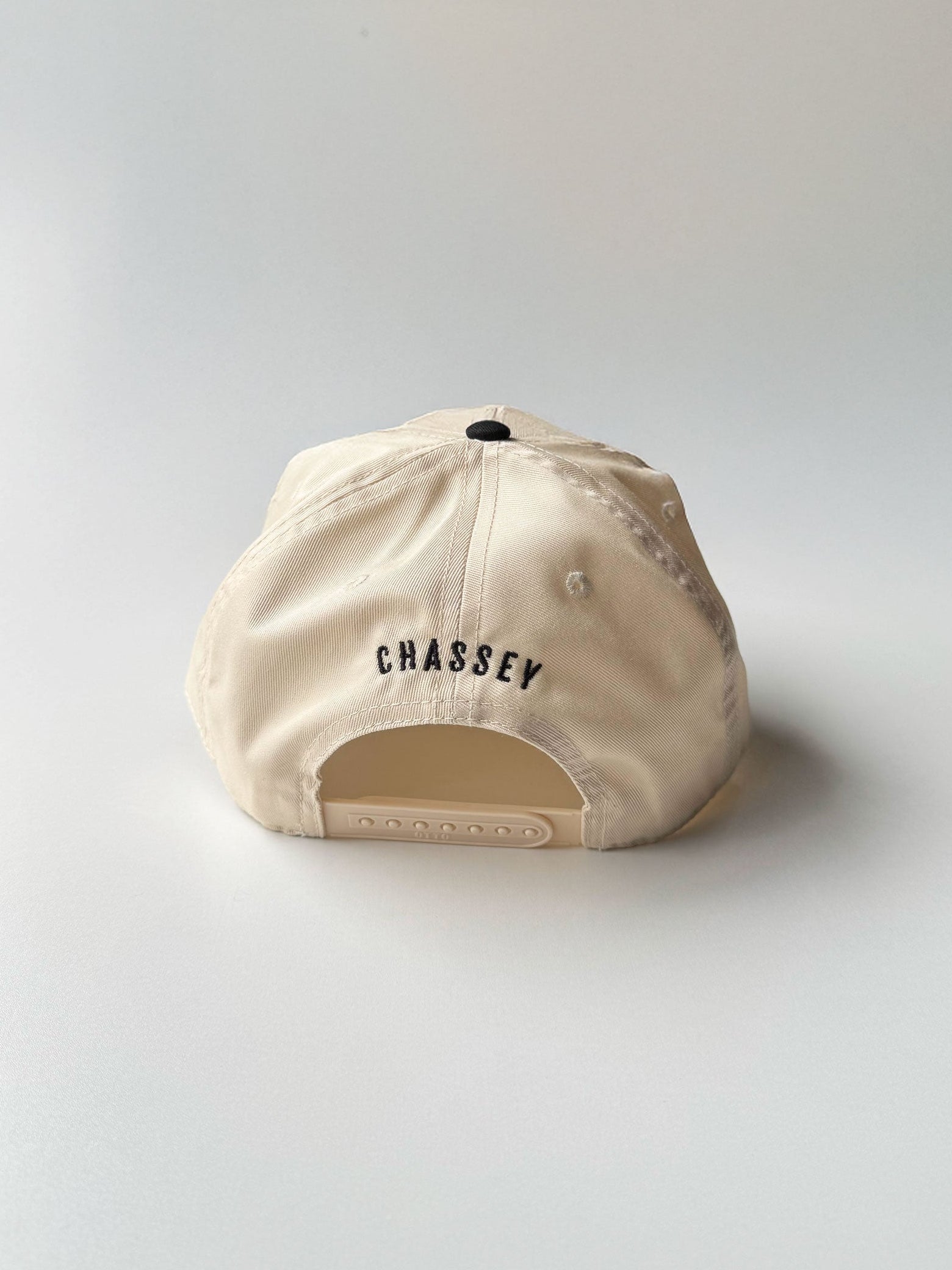 Back detail with Chassey brand embroidered, Peak Performance two-tone baseball hat in cream and black embroidery